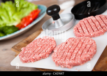 Fresche, hamburger fatti in casa in attesa di essere cucinato. Shallow d o f Foto Stock