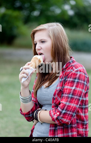 Ragazza adolescente a mangiare il gelato all'aperto Foto Stock