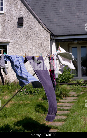 Linea di lavaggio con vestiti in giardino cottage. Questo è il modo tradizionale di asciugatura della biancheria, con sole splendente e una buona brezza Foto Stock