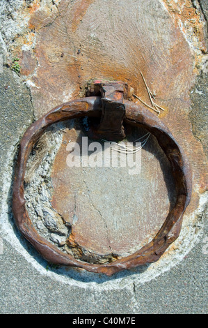 Anello di ferro lato banchina port harbour costa ruggine costiere arrugginita indossato vecchia industria marina nave marittima anchor tether banchina di ormeggio Foto Stock