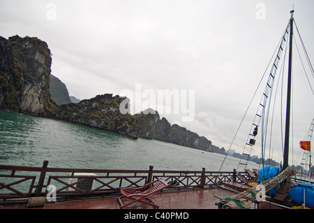 Vista orizzontale delle pietre calcaree carsiche (rocce) nella baia di Halong dal ponte di una tradizionale Giunca in legno usato per le guide di giro. Foto Stock