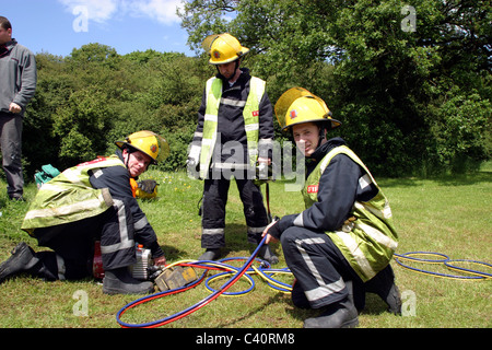 I vigili del fuoco di stivaggio ingranaggi di taglio sulla scena di un incidente Foto Stock