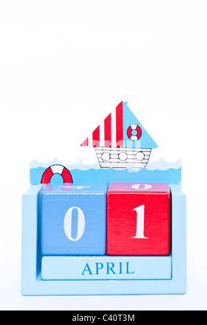 Un calendario di legno che mostra la data del mese di aprile il primo ( Il giorno di sciocchi di aprile ) su sfondo bianco Foto Stock