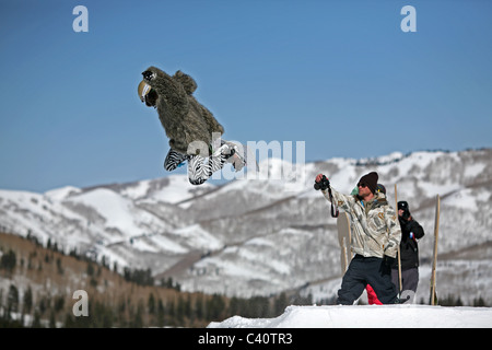 Snowboarder in fancy dress effettua un salto davanti alle telecamere durante un concorso a Brighton Ski Resort Foto Stock