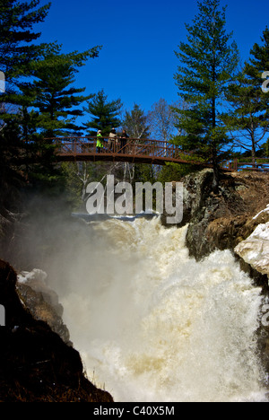 Gruppo in piedi sul ponte su sette infuriano le cascate del fiume Maskinongé Parc Des scivoli de Saint Ursule Mauricie regione Québec Foto Stock