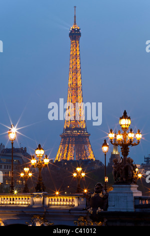 Lampione sul ponte di Alexander III, contro lo sfondo della torre Eiffel di notte. Parigi, Francia. Foto Stock