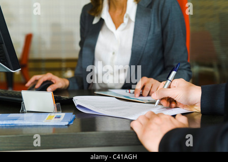 Persona che firma di documenti cartacei, metà sezione Foto Stock