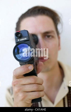 Messa a fuoco selettiva ritratto di uomo in possesso di una vecchia Canon super-8 telecamera cinematografica Foto Stock