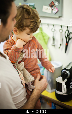 Padre azienda giovane figlio durante la preparazione di caffè espresso Foto Stock