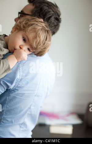 Il Toddler boy in appoggio sulla testa del padre shoudler Foto Stock