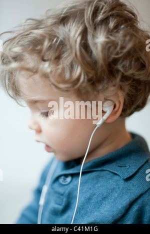 Il Toddler ragazzo indossa gli auricolari, profilo Foto Stock