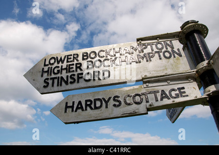 Un vecchio cartello in legno indica la strada per la Thomas Hardy's cottage a maggiore bockhampton, e alla chiesa stinsford, dove è sepolto. dorset, Inghilterra. Foto Stock
