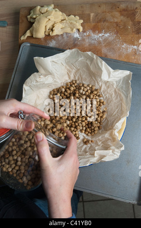 Non vedenti la cottura i fagioli che viene versato in un pezzo di carta impermeabile ai grassi REGNO UNITO Foto Stock