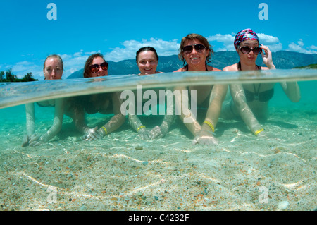 A livello diviso, gruppo womans concia giacente in acqua, leopatra isola (Sedir Island), il Mare Egeo, Turchia Foto Stock