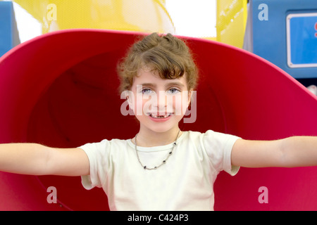 Brunette frastagliata ragazza sorridente in rosso il parco giochi occhi blu ritratto Foto Stock