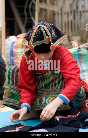 Un etnia Hmong hilltribe donna è la vendita di merci in un mercato di strada in Laos comunista. Foto Stock