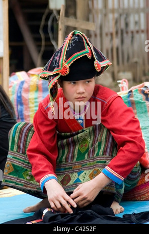 Un etnia Hmong hilltribe donna è la vendita di merci in un mercato di strada in Laos comunista. Foto Stock