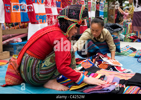 Etnia Hmong hill tribù le donne sono la vendita di merci in un mercato di strada in Laos comunista. Foto Stock
