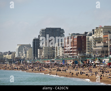 La gente seduta sulla spiaggia di Brighton Foto Stock