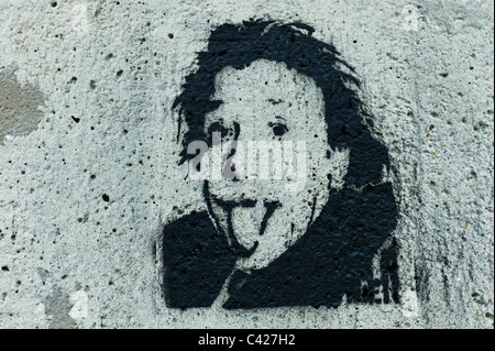 Stencil della testa di Albert Einstein inceppata / inserimenti fuori la sua lingua al visualizzatore sul grigio di un muro di cemento a Monaco di Baviera, Germania Foto Stock