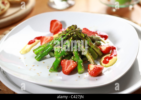 Antipasto - asparagi caramellate con fragole e salsa olandese Foto Stock