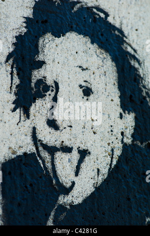 Stencil della testa di Albert Einstein inceppata / inserimenti fuori la sua lingua al visualizzatore sul grigio di un muro di cemento a Monaco di Baviera, Germania Foto Stock