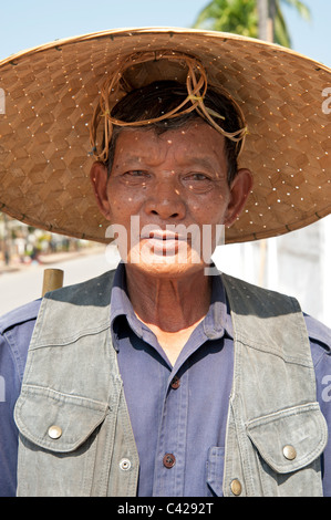 Lao uomo che indossa cappello di paglia fissando la videocamera a Luang Prabang la vecchia capitale reale del Laos Foto Stock