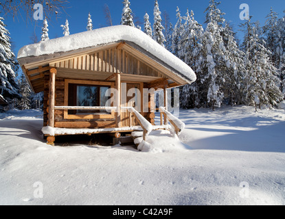 Piccola cabina di tronchi , in tronchi di abete rosso , nella foresta di taiga , in Inverno Finlandia Foto Stock