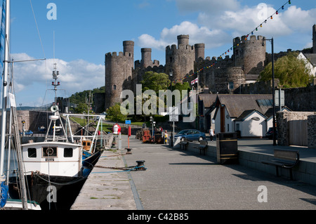 Il Quayside barche da pesca e castello di Conwy in Galles del Nord, Regno Unito. Situato sulle rive del fiume Conwy, Foto Stock