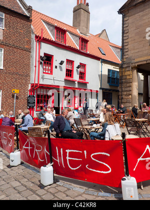 Turisti che si godono una sosta e ristoro presso i tavoli fuori Arnie's Bistro Café in luogo di mercato Whitby North Yorkshire Foto Stock