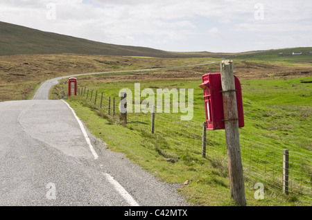 Voe, Northmavine, Isole Shetland Scozia, Regno Unito, Europa. Via unica strada di campagna e rosso Royal Mail postbox su un wonky post. Foto Stock