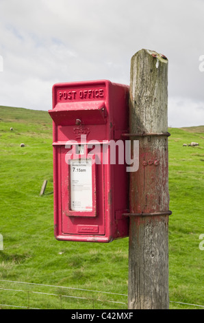 Voe, Northmavine, Isole Shetland Scozia, Regno Unito, Europa. Rosso rurale Royal Mail postbox su un palo di legno. Foto Stock