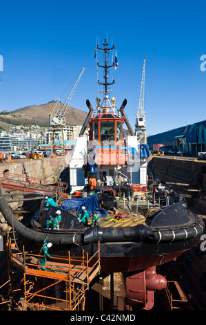 I lavoratori della riparazione di un rimorchiatore a traino in un bacino a secco a Città del Capo in Sud Africa Foto Stock