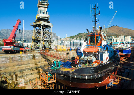 I lavoratori della riparazione di un rimorchiatore a traino in un bacino a secco a Città del Capo in Sud Africa Foto Stock