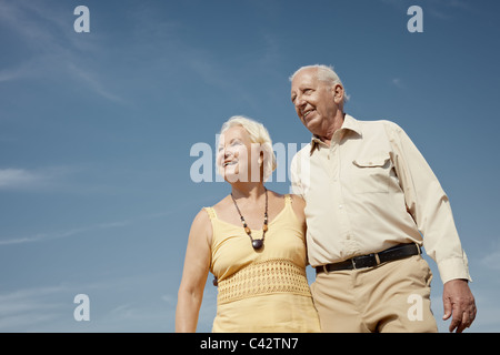 Senior coppia caucasica camminando sulla giornata di sole e avvolgente. Sagoma orizzontale a basso angolo di visione, spazio di copia Foto Stock