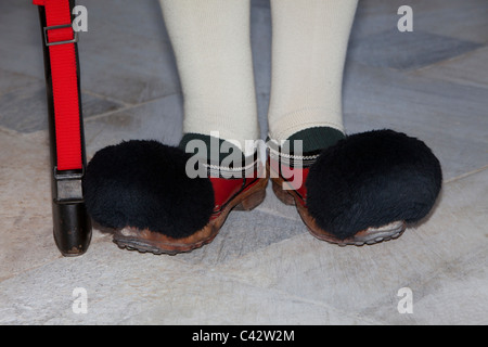 Red tsarouhi zoccoli di cuoio nero con un pompon del Evzones presso la tomba del Milite Ignoto a Atene, Grecia Foto Stock