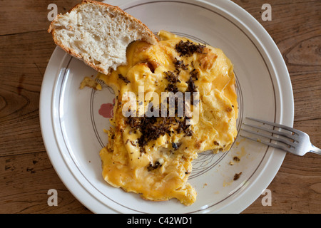 La frittata guarnita con un fresco e tartufo nero trucioli e pane francese Foto Stock