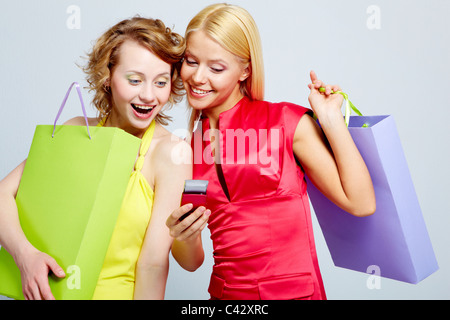 Splendida shoppers lettura sms sul cellulare Foto Stock