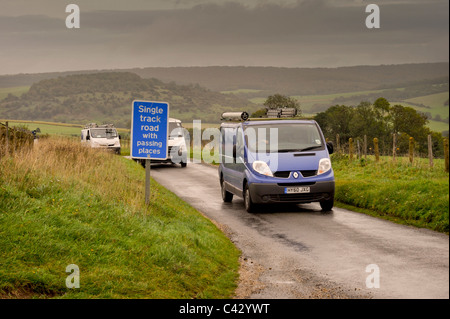 Vari furgoni squeeze attraverso una singola traccia strada alta sulle Downs sopra in Chichester West Sussex. Foto Stock