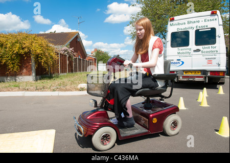 Una giovane ragazza disabili imparare a guidare uno scooter di mobilità in tutta sicurezza presso il Centro per gli studi sulla disabilità a Rochford, Essex, Regno Unito. Foto Stock