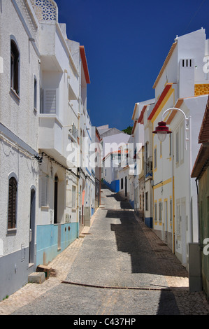 Stretta strada acciottolata nella Città Vecchia, Salema, Algarve Regione, Portogallo Foto Stock