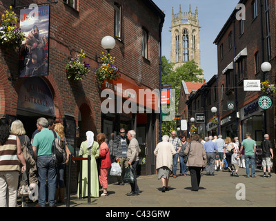 Persone che si trovano fuori dal Jorvik Viking Centre Coppergate e All Saints Church sullo sfondo York North Yorkshire Inghilterra Regno Unito GB Foto Stock