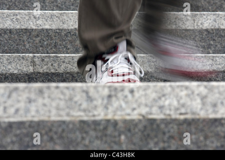 Le gambe di un maschio scendendo alcuni gradini Foto Stock