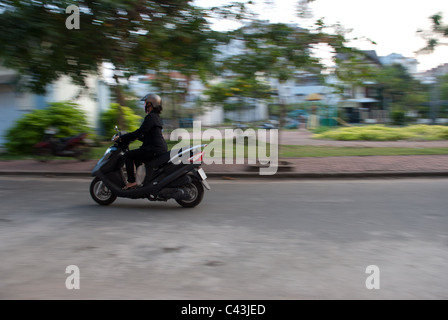 La donna in sella a una moto a Saigon Vietnam Foto Stock