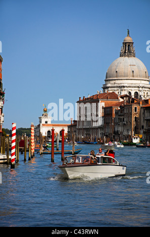 Venezia, taxi d'acqua con i turisti con Santa Maria della Salute in background Italia Europa Foto Stock