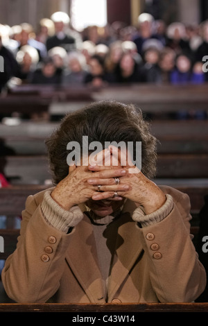 Vecchia donna in preghiera nella chiesa Foto Stock