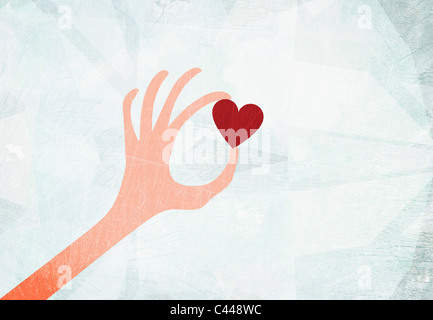 Una mano che regge un cuore Foto Stock