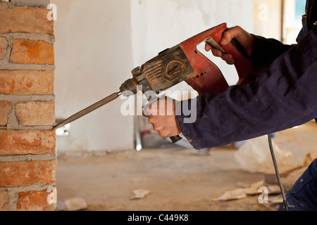 Un lavoratore edile utilizzando un trapano jackhammer Foto Stock