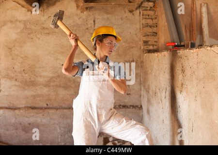 Una femmina di lavoratore edile di brandeggiare la mazza Foto Stock