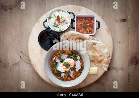 Un indiano piatto di pollo al curry, pane naan, ceci e riso. Foto Stock